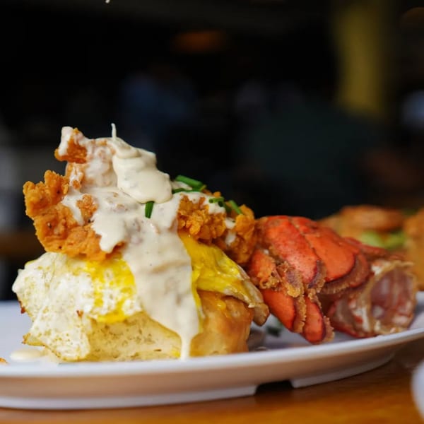 The Real Milk & Honey's lobster and fried chicken on a biscuit with gravy and fried egg.