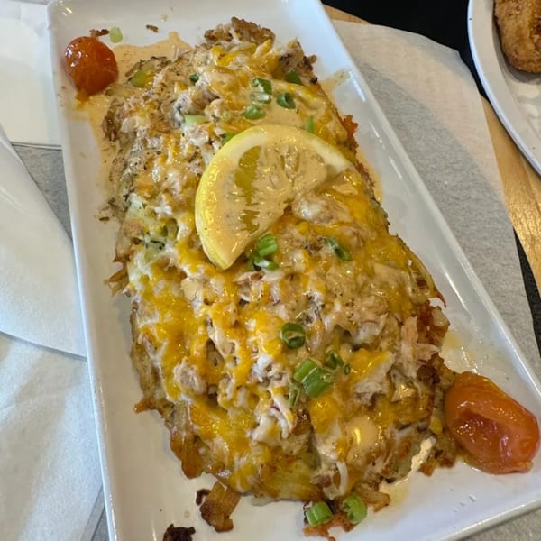 The Real Milk & Honey's crab and cheese omelet with a lemon slice and roasted tomatoes.